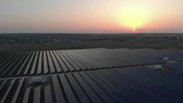 Blick aus der Luft in große Sonnenkollektoren auf einem Solarpark bei Sonnenuntergang. Solarzellenanlagen. Videomaterial 4k. — Stockvideo