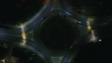 Küçük Avrupa şehrinde gece vakti yuvarlak arabalarla dolambaçlı yolun hava görüntüsü