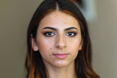 Makyaj sürecinde güzel bir model. Güzellik salonundaki güzel makyajlı güzel bir kadının portresi. Akşam makyajı, bulanık arkaplan