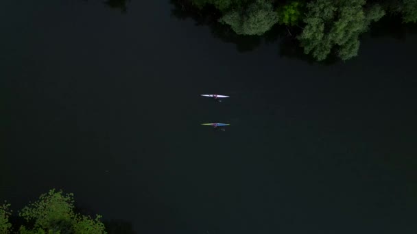 Küçük nehirde bir kuzguna binen iki adamın, kuş bakışı görüntüsü 4K. — Stok video