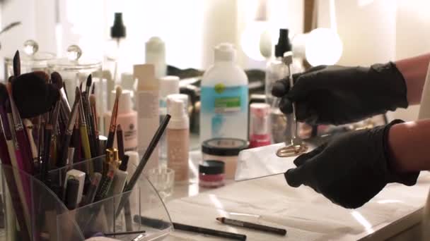 Handen van professionele make-up kunstenaar toe te passen foundation cream op het palet te mengen en toe te passen op het gezicht, close-up te bekijken — Stockvideo