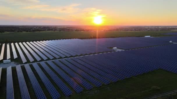 Luftaufnahme großer Sonnenkollektoren auf einem Solarpark bei strahlendem Sommersonnenuntergang. Solarzellenanlagen. Videomaterial 4k. — Stockvideo