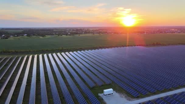 Вид з повітря на великі сонячні панелі на сонячній фермі на яскравому літньому заході сонця. Електростанції сонячних батарей. відеозйомка 4k . — стокове відео