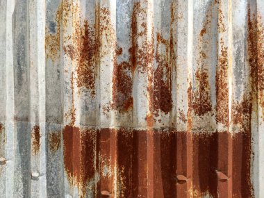 Aşınmış metal zemin. Paslı, gri, tırtıklı metal bir duvar. Paslı metal arka planda pas izleri var. Pas lekeleri. Metal yüzey paslanmış lekeler. Rystycorrosion.