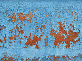 Rusty kovový panel s popraskanou modrou barvou, korodované grunge kovové pozadí textury