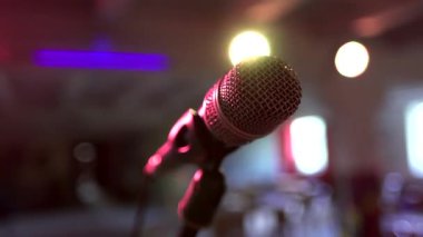 Sahnedeki mikrofon görüntüsünü kapatın. Rock Cafe Bar 'daki boş oditoryuma bakın. Renkli spot ışıkları