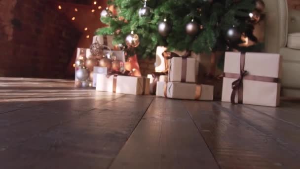 Χριστουγεννιάτικες διακοσμήσεις δέντρων στο στούντιο με χριστουγεννιάτικη και πρωτοχρονιάτικη εσωτερική διακόσμηση. Πράσινο δέντρο διακοσμημένο με μικρές γυάλινες μπάλες. Δώρα κάτω από το δέντρο. — Αρχείο Βίντεο