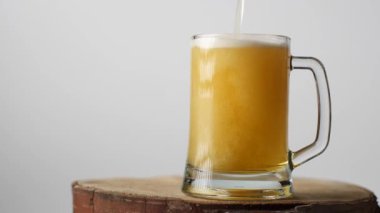 Bira bir bira bardağına dökülür, bir tutacağı olan, bir sürü köpük ve köpük bardaktan aşağı akar..