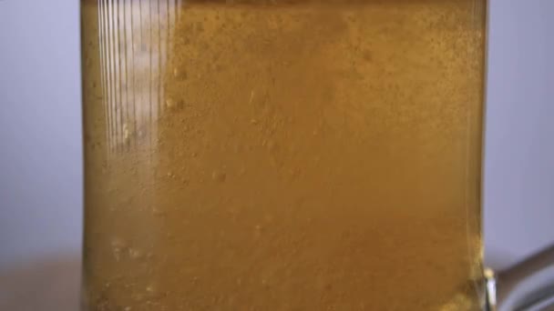 Close-up slow motion shot of light beer is poured into a beer glass with a handle, a lot of bubbles and foam — Stock Video