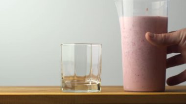 Çiğ vejetaryen çilekli smoothie bardağı dolduruyor. Masaya yeni karıştırılmış meyve püresi koydum.