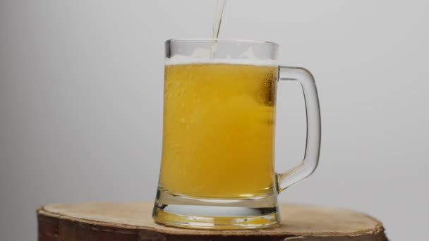 La bière est versée dans un verre à bière avec une poignée, beaucoup de bulles et de mousse. — Video