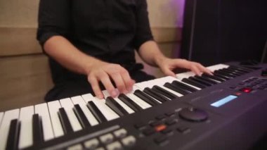 Klavyeci parmaklarına seçici odaklanma. Konser için müzik aleti ya da öğrenme müziği var. Stüdyoda rehabilitasyonda piyano çalan müzisyenin eli kapalı..