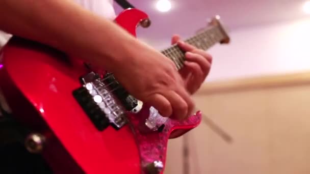 Nahaufnahme männlicher Gitarristenhände, die auf roter E-Gitarre spielen — Stockvideo