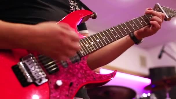 Nahaufnahme männlicher Gitarristenhände, die auf roter E-Gitarre spielen — Stockvideo