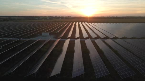 明るい日没で太陽光発電所の大きな太陽電池パネルに空中ドローンビュー。太陽電池発電所。映像ビデオ4k. — ストック動画