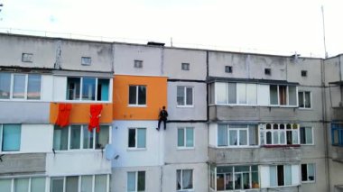 Boyama ve dekorasyon binaları. Yüksek bir binanın şantiyesinde çalışan bir işçi. Yüksek irtifa mühendisliği tasarımı için tehlikeli bir iş. Demir ve beton.