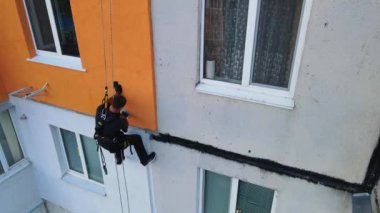 Boyama ve dekorasyon binaları. Yüksek bir binanın şantiyesinde çalışan bir işçi. Yüksek irtifa mühendisliği tasarımı için tehlikeli bir iş. Demir ve beton.