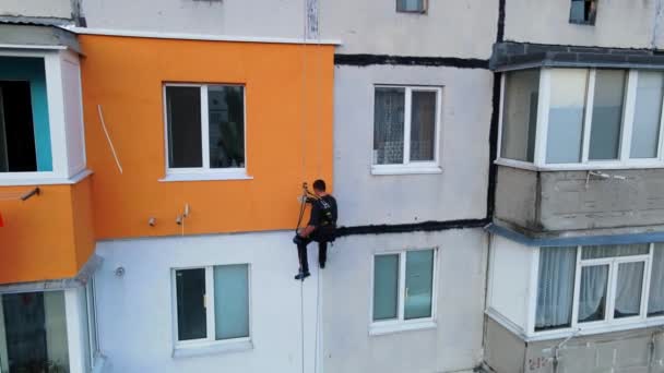Painting and decorating buildings. Worker on a construction site of a high-rise building. Dangerous work in high-altitude engineering design. Iron and concrete. — Stock Video