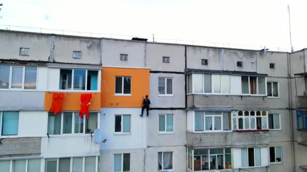 Malerei und Dekoration von Gebäuden. Arbeiter auf einer Baustelle eines Hochhauses. Gefährliche Arbeit in Höhenlagen. Eisen und Beton. — Stockvideo