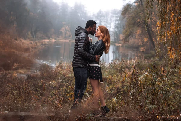 秋にポーズをとる異人種間のカップル背景 黒男と白の赤毛の女性 — ストック写真