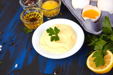 Ev yapımı Sos mayonez ve malzemeler yumurta, yağ, limon, koyu mavi zemin üzerine mustar. Top vie