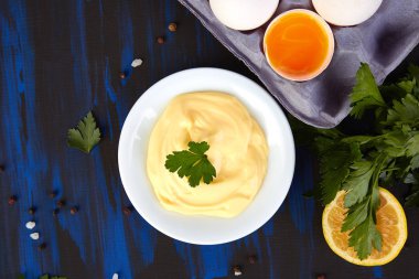 Ev yapımı Sos mayonez ve malzemeler yumurta, yağ, limon, koyu mavi zemin üzerine mustar. Top vie