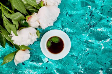 Günaydın. Çay ve yeşil zemin üzerine beyaz şakayık buket. Düz yatıyordu. Üstten görünüm. Kopya alanı.