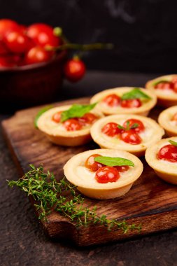 Mini tart kiraz domates ile ahşap tahta üzerinde mozzarella peyniri ile.