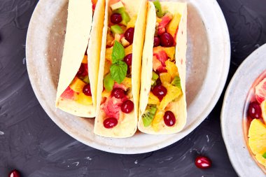 Portakal, kivi, greyfurt koyu arka plan ve berry meyve Taco. Yaz aperatifler. Üstten Görünüm. Kopya alanı