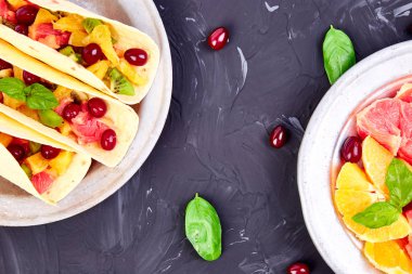 Portakal, kivi, greyfurt koyu arka plan ve berry meyve Taco. Yaz aperatifler. Üstten Görünüm. Kopya alanı
