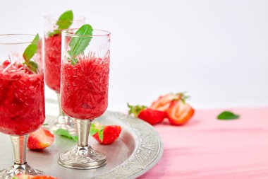 Çilek şerbetler serinletici yaz, granita içecek gözlük gümüş tepsi üzerinde hizmet içinde slush. Sağlıklı düşük kalorili yaz tedavi, tatlı. Pembe bir arka plan üzerinde Buzlu kokteyli.