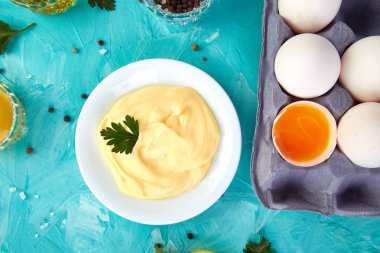 Ev yapımı Sos mayonez ve malzemeler yumurta, yağ, limon, mavi zemin üzerine mustar. Top vie