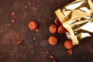 Çikolata çikolata truffles altın lüks kutusunu kahverengi zemin üzerine düşmek. Alan, tatlı kopyalayın. Kakao şekerler. lezzetli. lezzetli. Düz yatıyordu