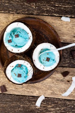 Dondurmalı çikolata Hindistan cevizi kase ahşap zemin üzerine mavi. Yaz yiyecek. Üstten Görünüm. Kopya alanı.