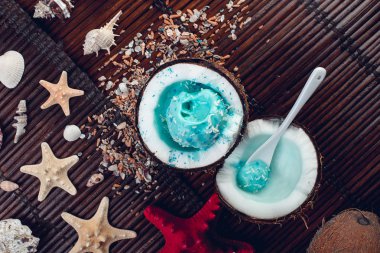 Hindistan cevizi kase kum, deniz, deniz yıldızı yakınındaki mavi dondurma.