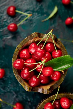 Kase yeşil zemin üzerine kırmızı kiraz. Yaz veya bahar kavramı. Hasat. Üstten görünüm. Düz yatıyordu