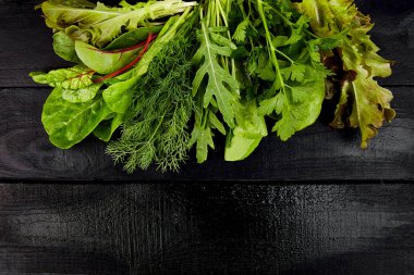 Yaprak salata siyah masada karıştırın. Düz yatıyordu. Uzay kopyalayın. Marul, mangold, maydanoz, dere otu, roka sağlıklı beslenme açık yiyecek Vegan