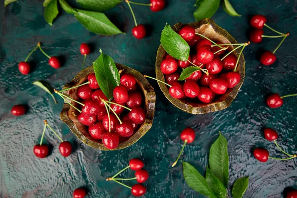 Kase yeşil zemin üzerine kırmızı kiraz. Yaz veya bahar kavramı. Hasat. Üstten görünüm. Düz yatıyordu