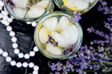 Lavanta Limonata limon ve siyah arka plan üzerine buz. Suyu detoks. Yaz içeceği. Diyet kokteyl. Güzel. Üstten görünüm. Kopya alanı.