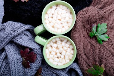 İki fincan kahve ya da sıcak çikolata hatmi üç yakınındaki gri, siyah ve kahverengi süveter örme veya battaniye örme. Sonbahar kavramı. Noel. Üstten Görünüm. Evde sıcak