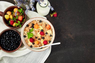 Sağlıklı vejetaryen kahvaltı. Yulaf ezmesi, granola ahududu ve yaban mersini kase üzerinde kahverengi zemin, buket lavanta ile. Üstten görünüm. Düz yatıyordu. 