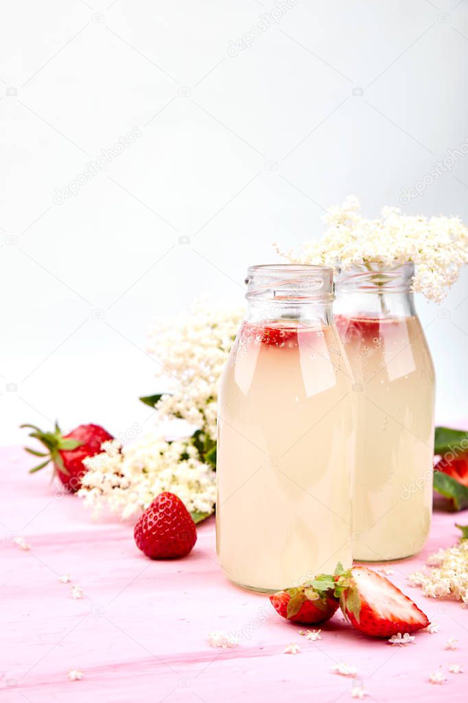 Kombucha tea with elderflower and strawberry on pink background. Homemade fermented infused drink. Summer Healthy natural probiotic flavored drink. Copy space