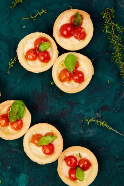 Mini tart kiraz domates yeşil zemin üzerine mozzarella peyniri ile. Üstten Görünüm.