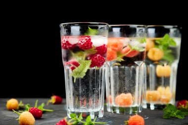 Aromalı su üç rengiyle ahududu - infused detoks kırmızı, turuncu, siyah zemin üzerine sarı... Canlandırıcı yaz ev yapımı cocktai