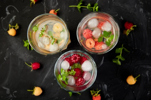 Aromalı su üç rengiyle ahududu - infused detoks kırmızı, turuncu, siyah zemin üzerine sarı... Canlandırıcı yaz ev yapımı cocktai