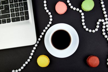 Tatlı tatlı Macaron veya kahve ile acıbadem kurabiyesi defter. renkli badem kurabiye, kek blak arka plan üzerinde. Düz yatıyordu. Uzay kopyalayın. Kadın işyeri. freelanc
