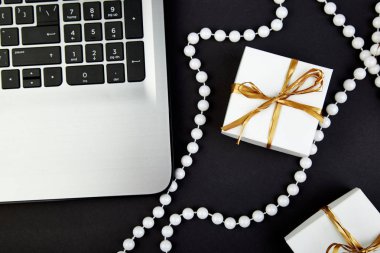 Beyaz hediye kutusu ile defter siyah arka plan üzerine yakınındaki altın şerit. Online Alışveriş Mağazası. Düz yatıyordu. Uzay kopyalayın. Bir hediye seçin
