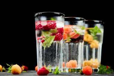 Aromalı su üç rengiyle ahududu - infused detoks kırmızı, turuncu, siyah zemin üzerine sarı... Canlandırıcı yaz ev yapımı cocktai