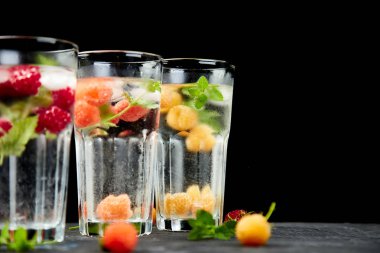 Aromalı su üç rengiyle ahududu - infused detoks kırmızı, turuncu, siyah zemin üzerine sarı... Canlandırıcı yaz ev yapımı cocktai