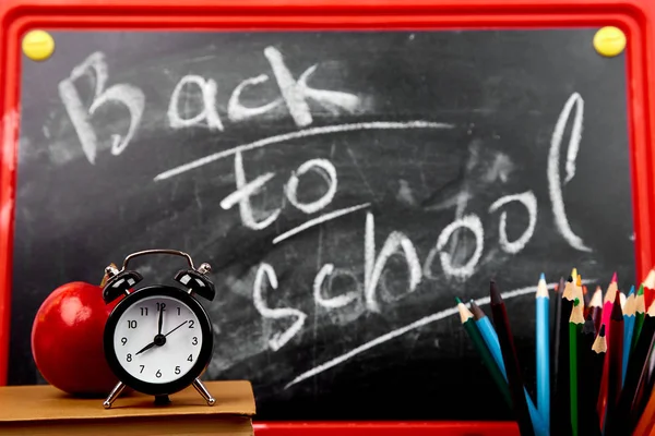 黒板背景に近い赤いリンゴとチョークと黒板レタリングを学校に戻る — ストック写真